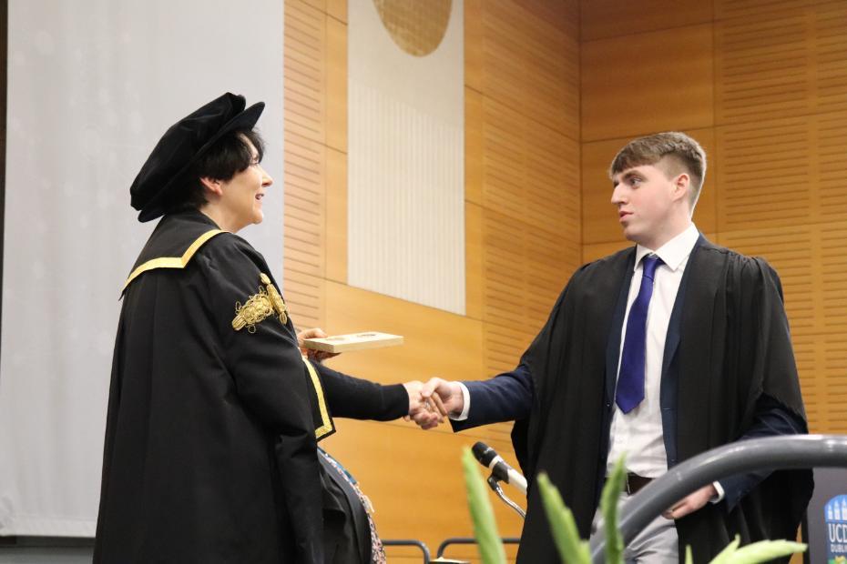 Adam McNally receiving his award from UCD President Professor Orla Feely